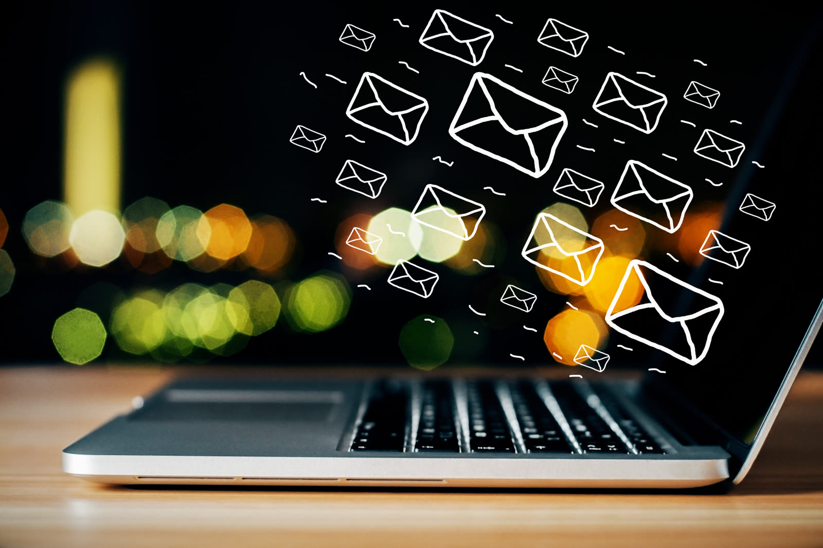 Small business owner checking email newsletter performance on a laptop at a counter