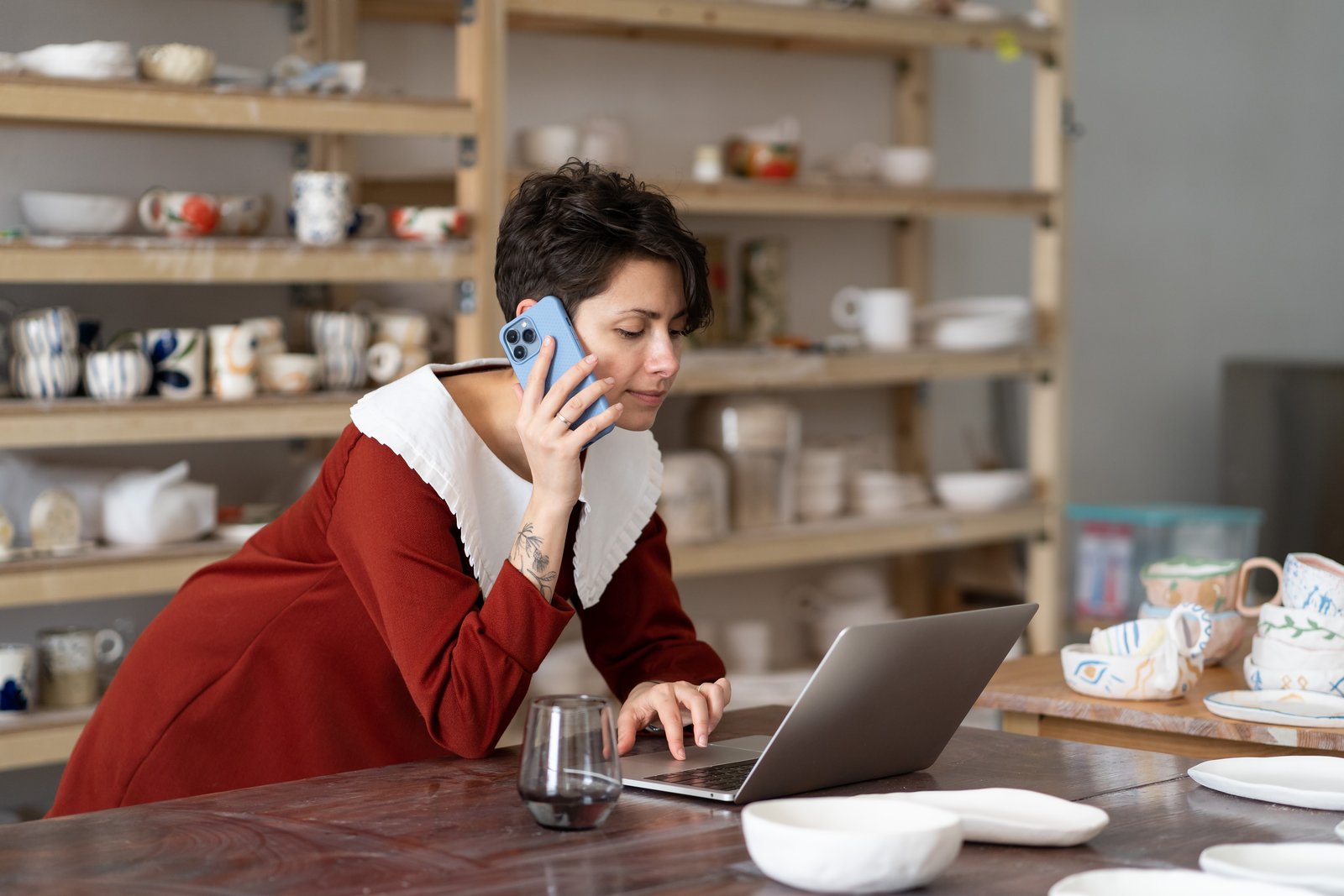 A small business owner calmly typing a reply on a phone at the counter of their shop.