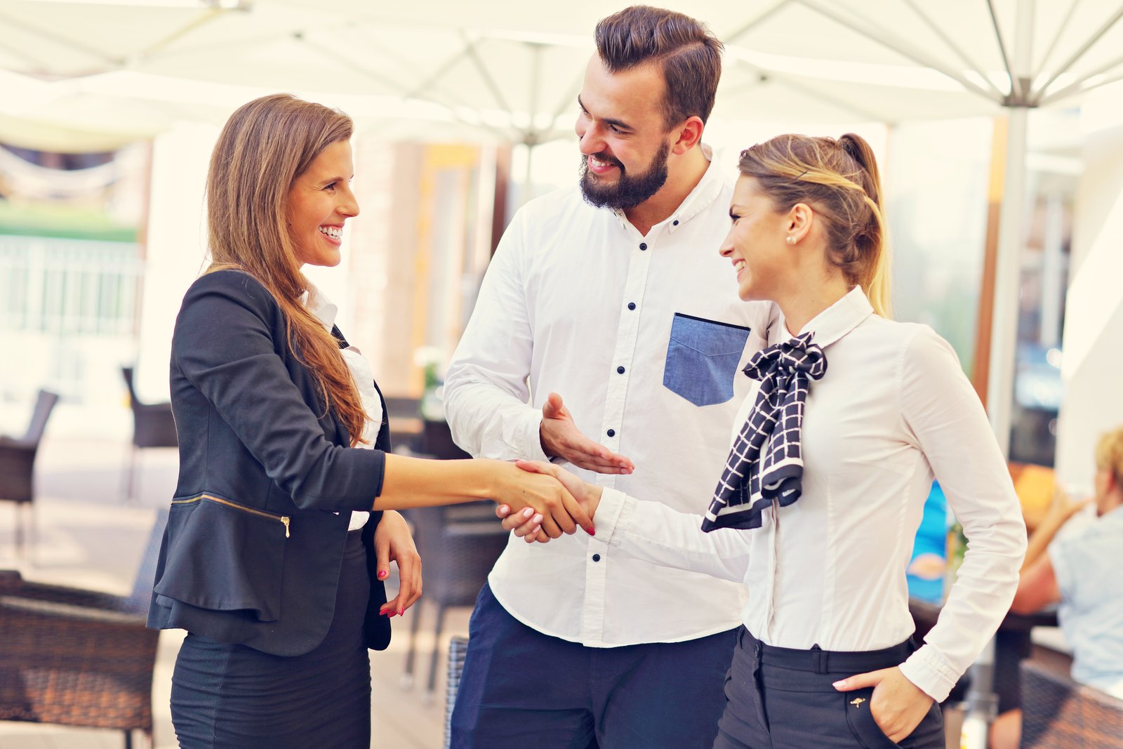 A small business owner in Oklahoma shaking hands with a chamber of commerce representative at a local networking event.