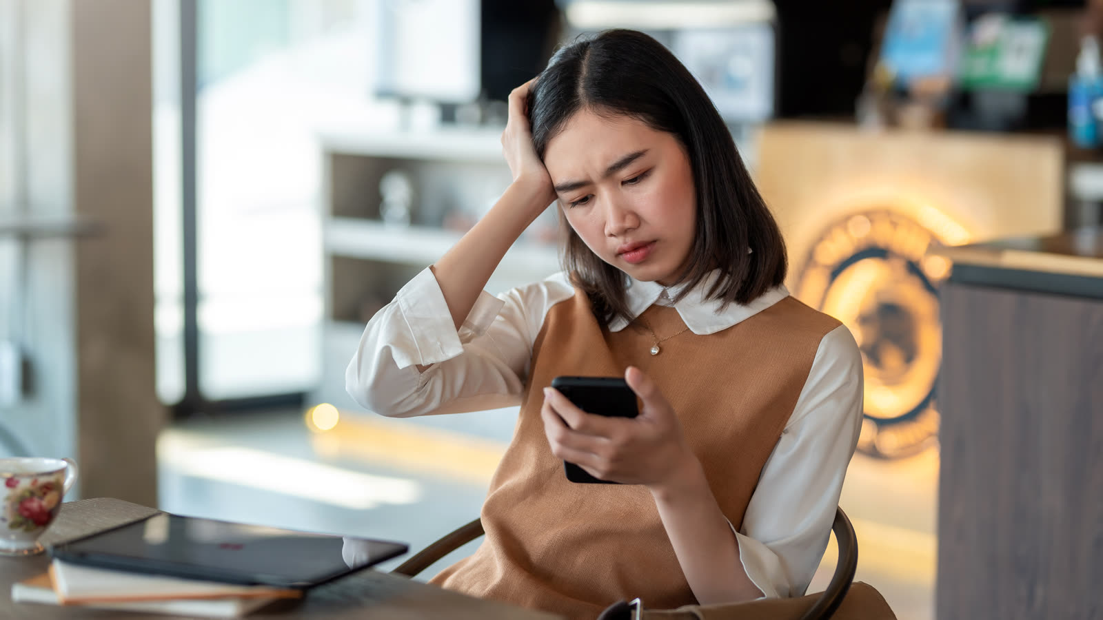 A small business owner checking their website speed on a smartphone in their shop