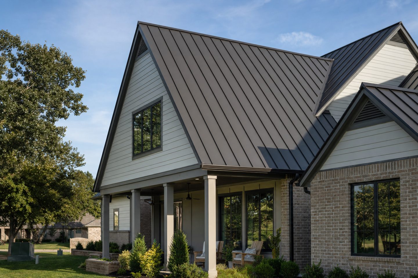 A dark bronze standing-seam metal roof on a modern farmhouse-style home