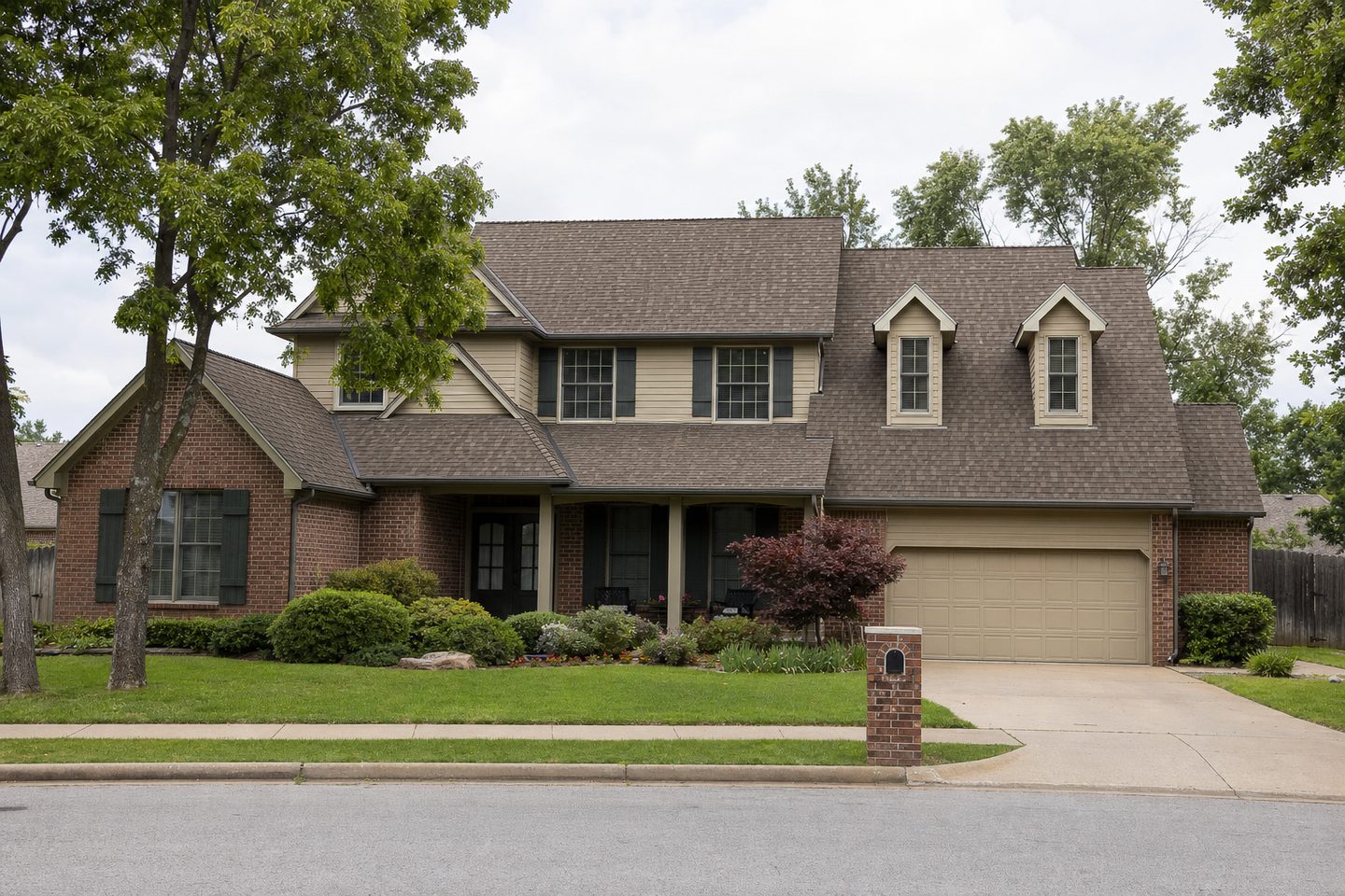 A two-storey house with dormers, freshly re-roofed in weathered-wood shingles